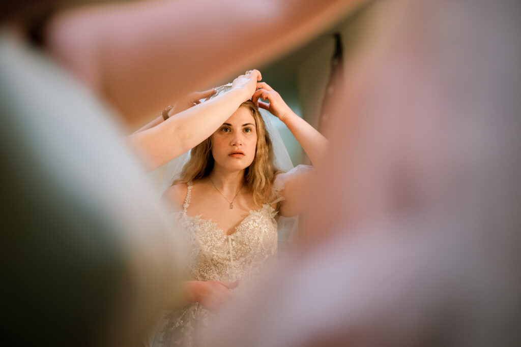 Bride has help adjusting her veil during getting ready