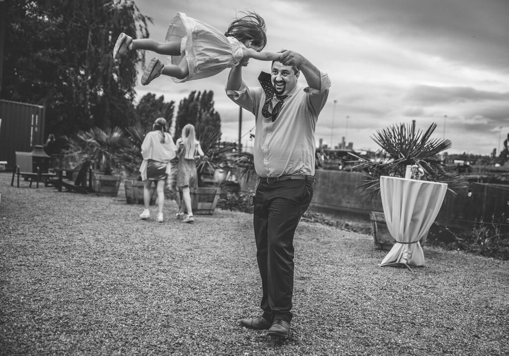 Dad swings young daughter around in circle as she flys through the air