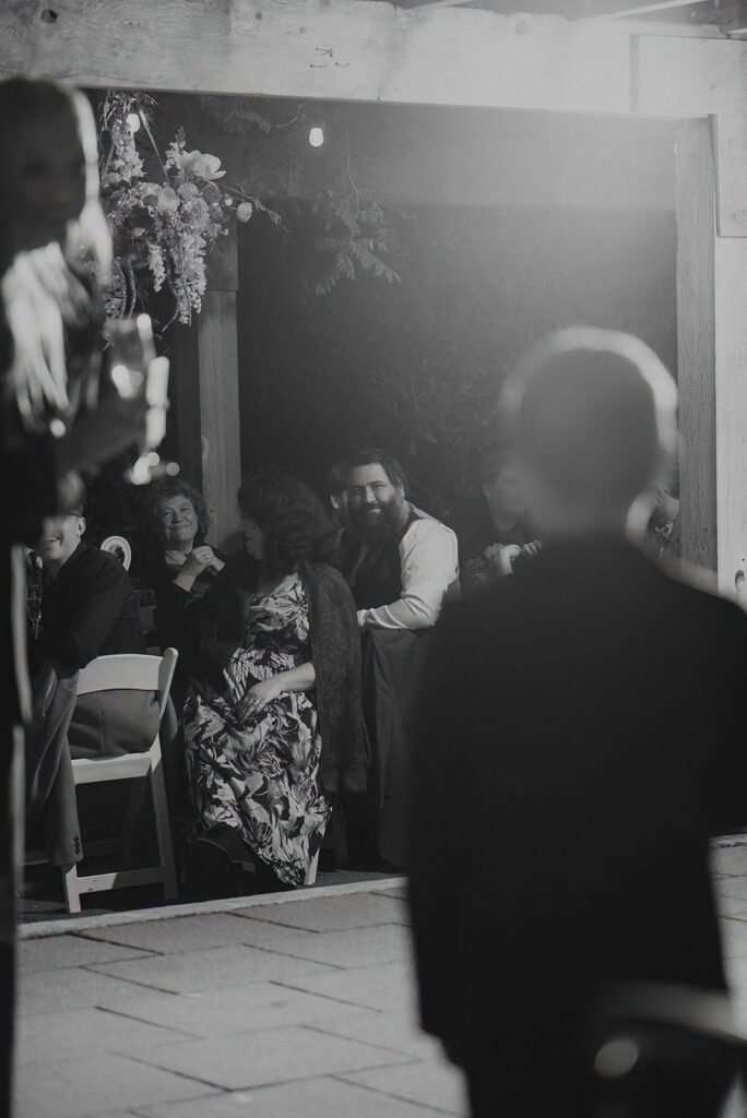 young boy delivers speech at a wedding while guests looks on and smile