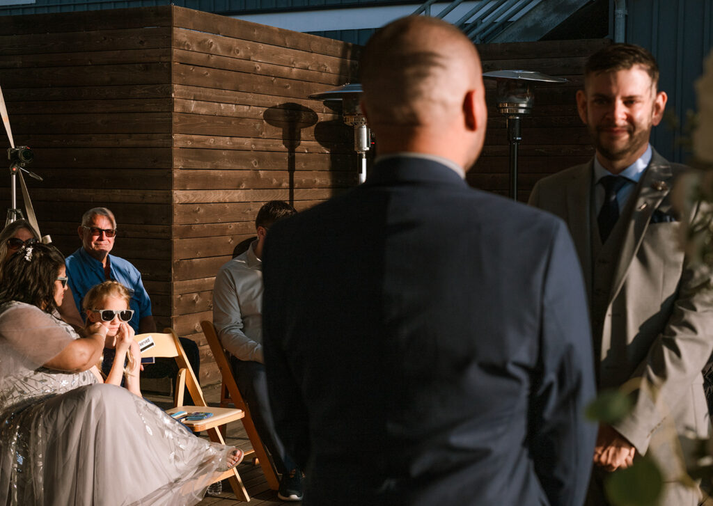 Daughter wipes away tears in the front row as her dads get married