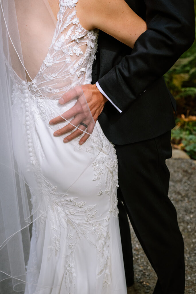 Grooms hands on brides waist as they dance
