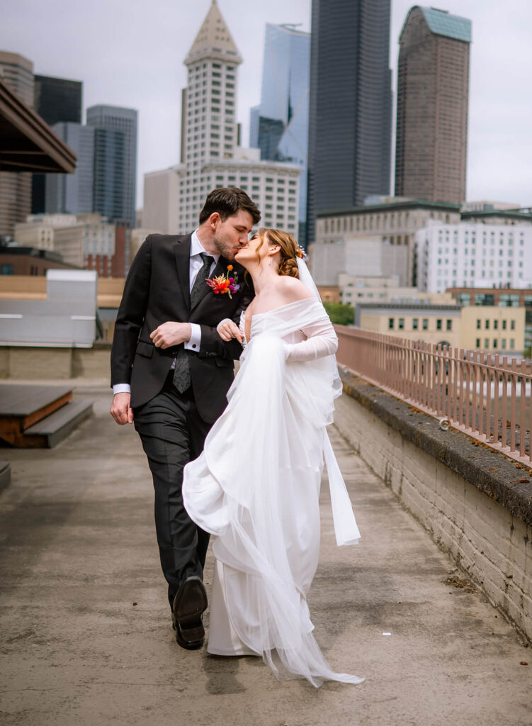 Couples kisses on their wedding day on the rooftop of europa in seattle