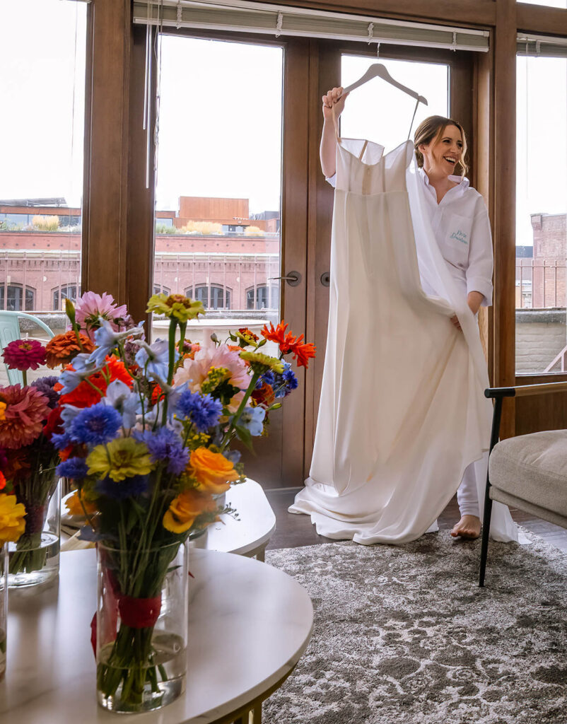 Bride holds dress in bridal suite at europa wedding seattle