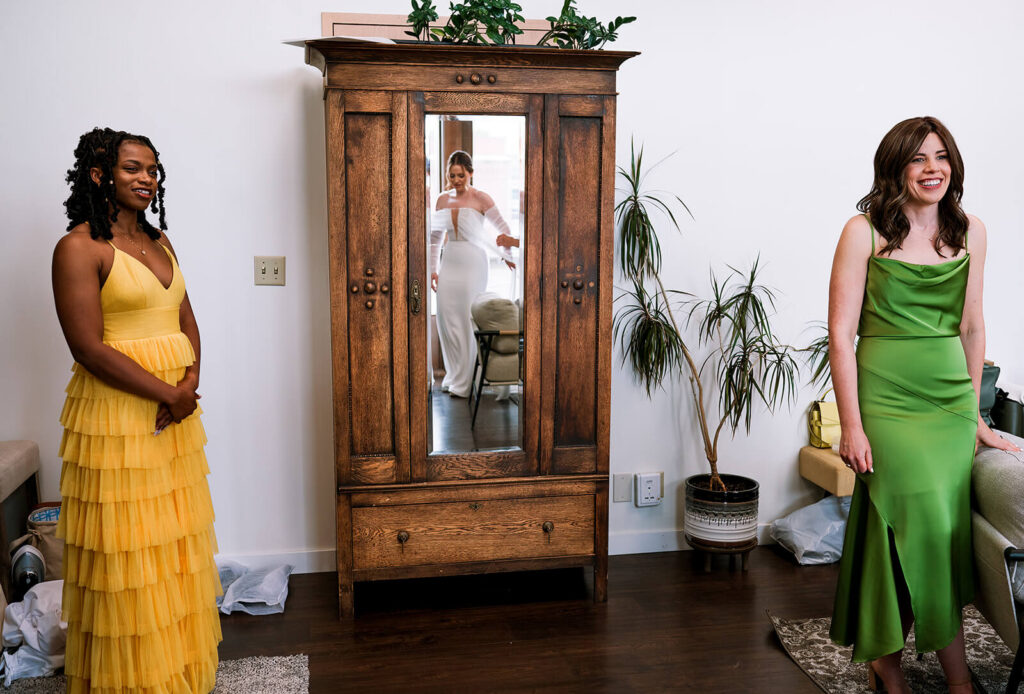 Bridesmaids watch bride twirl in her dress
